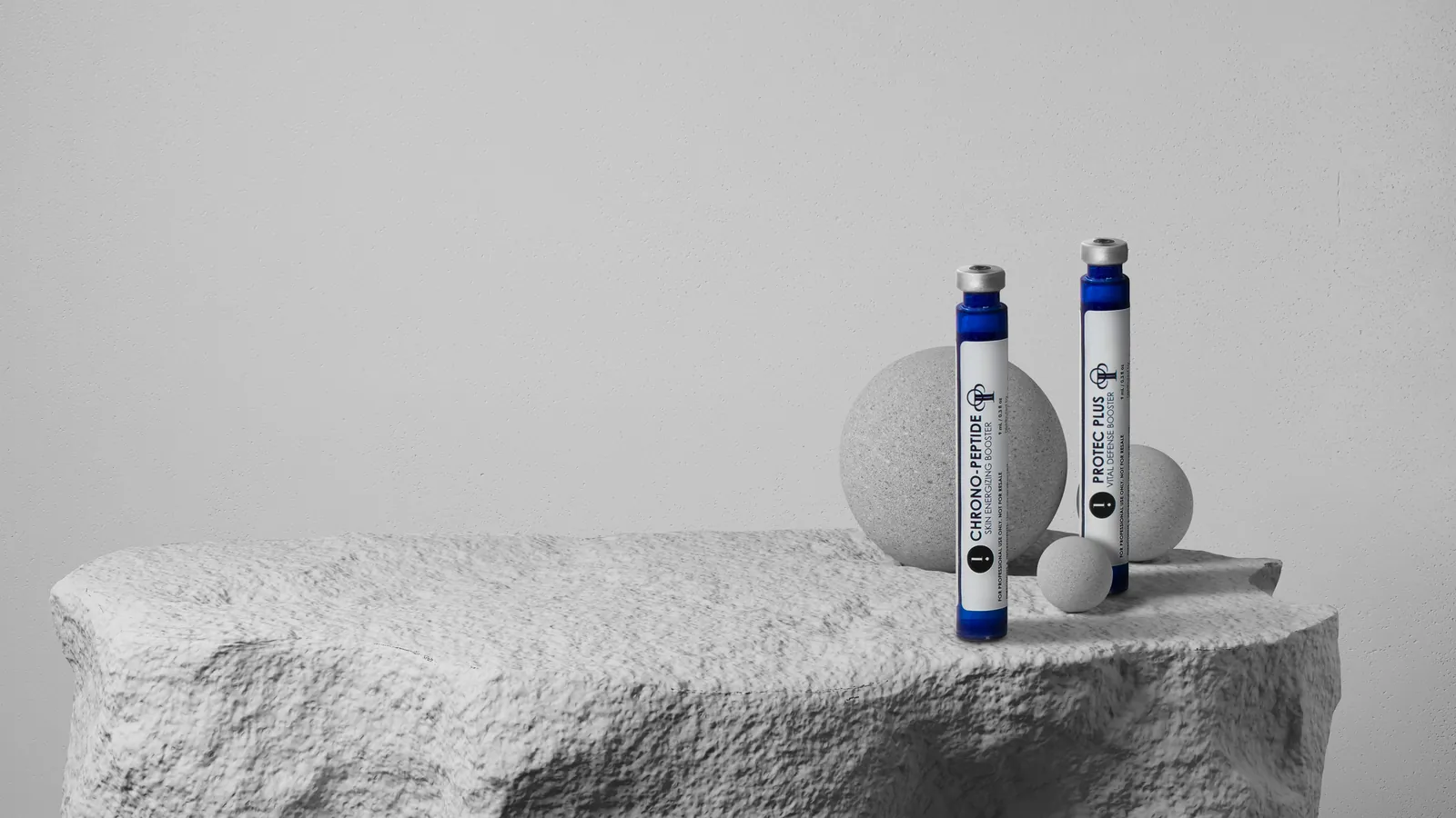 Două fiole de booster Circadia pentru Hydrafacial, Chrono-Peptide și ProTec Plus, așezate pe un bloc de piatră deschisă la culoare